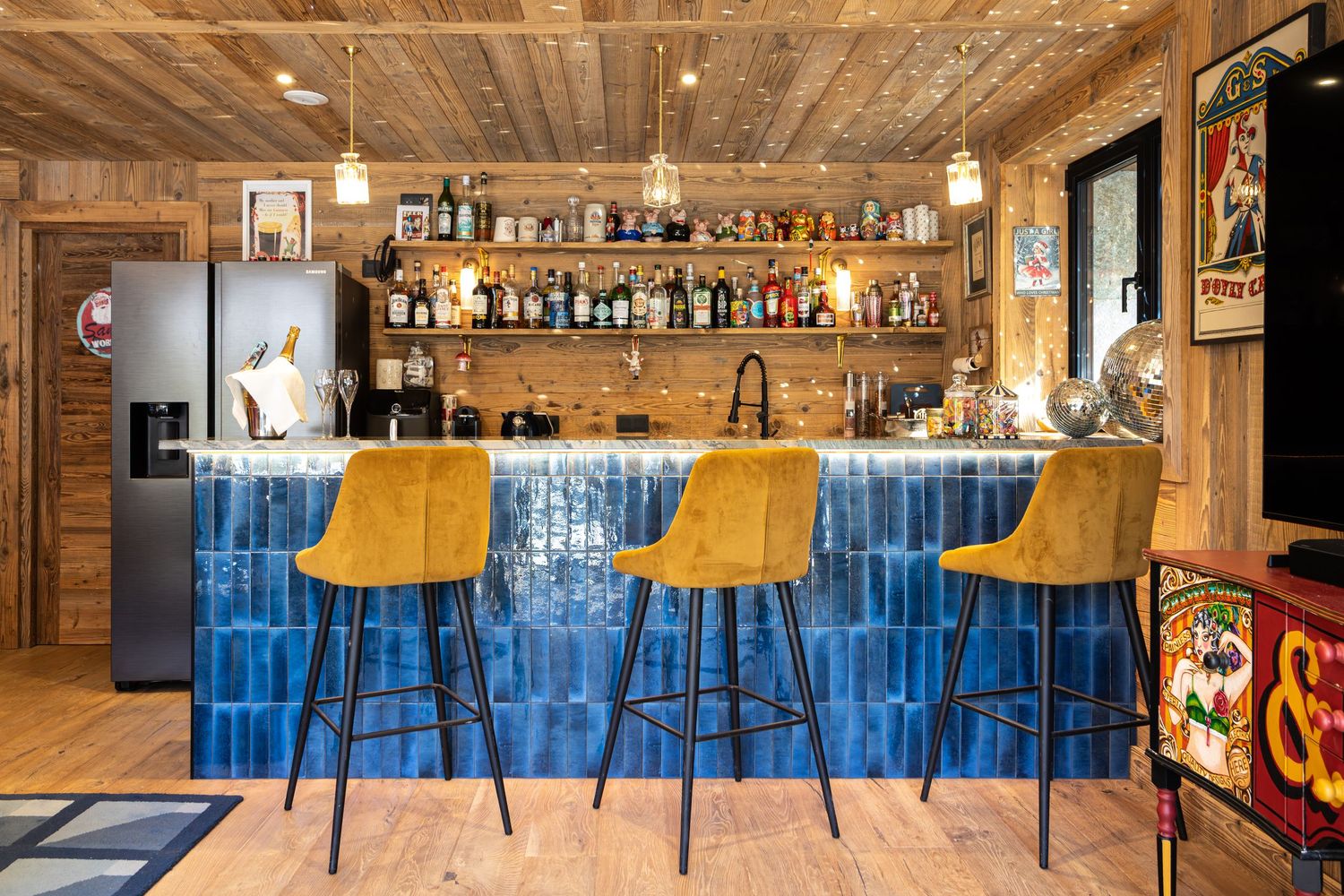 blue tiled bar with three yellow bar stools