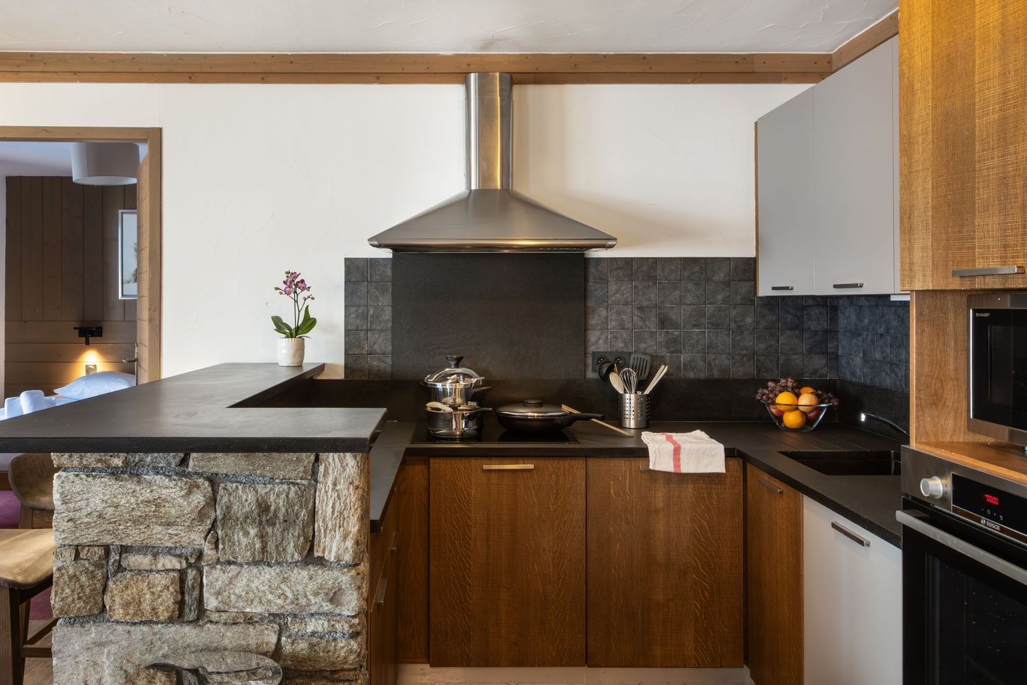 sleek contemporary kitchen with black work tops in ski apartment