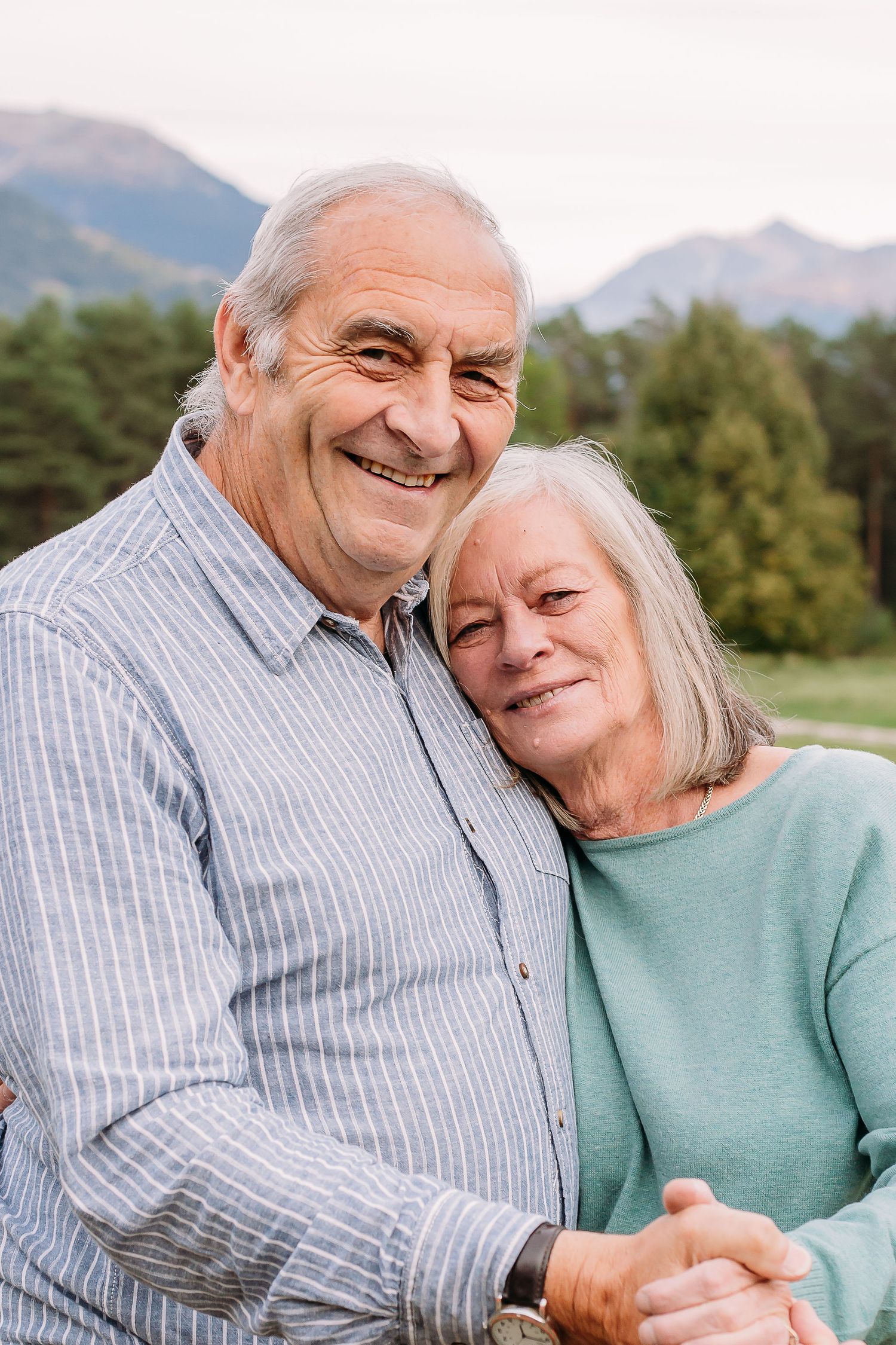 Older couple dance holding hands in mountains