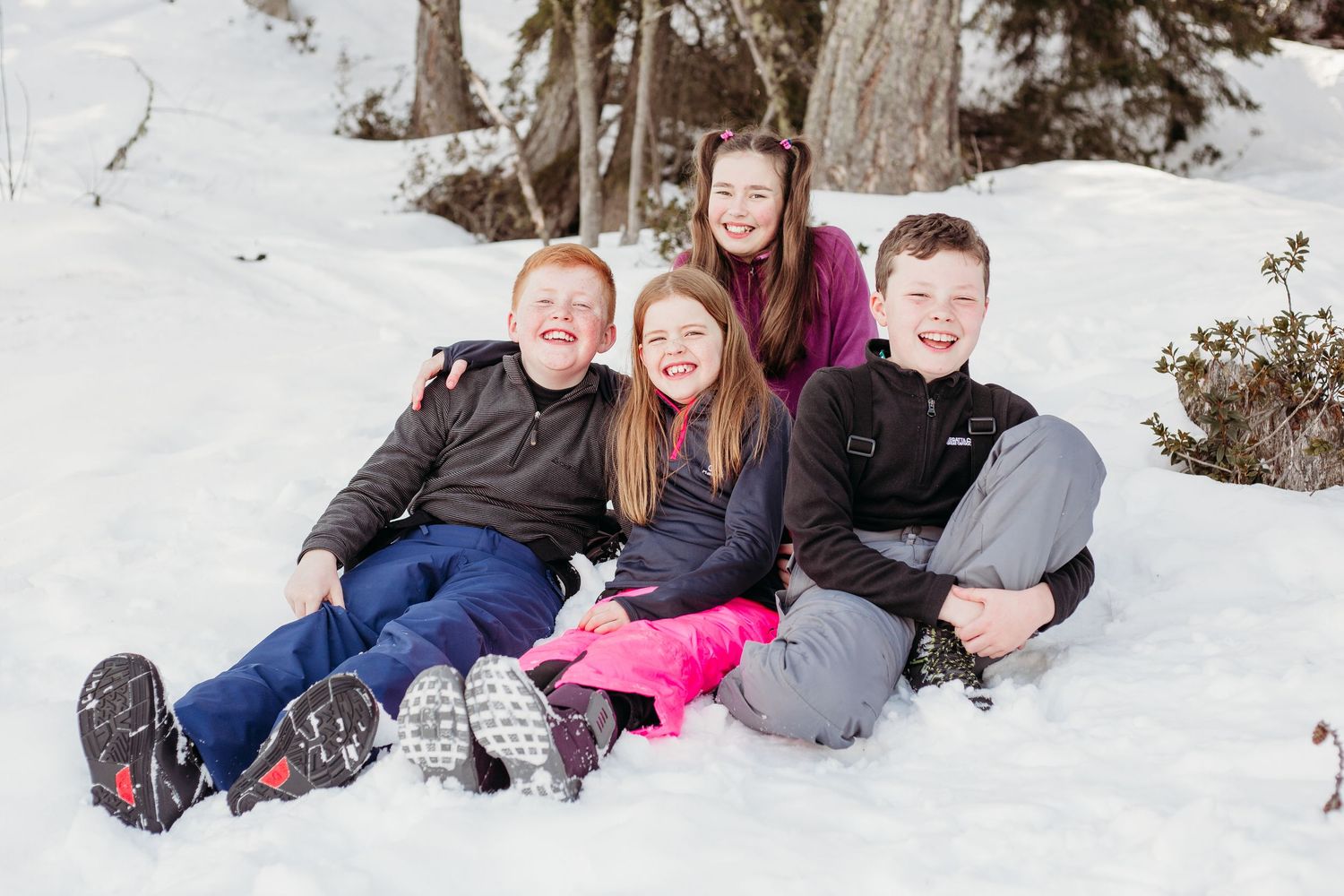 4 children cousins play in the snow
