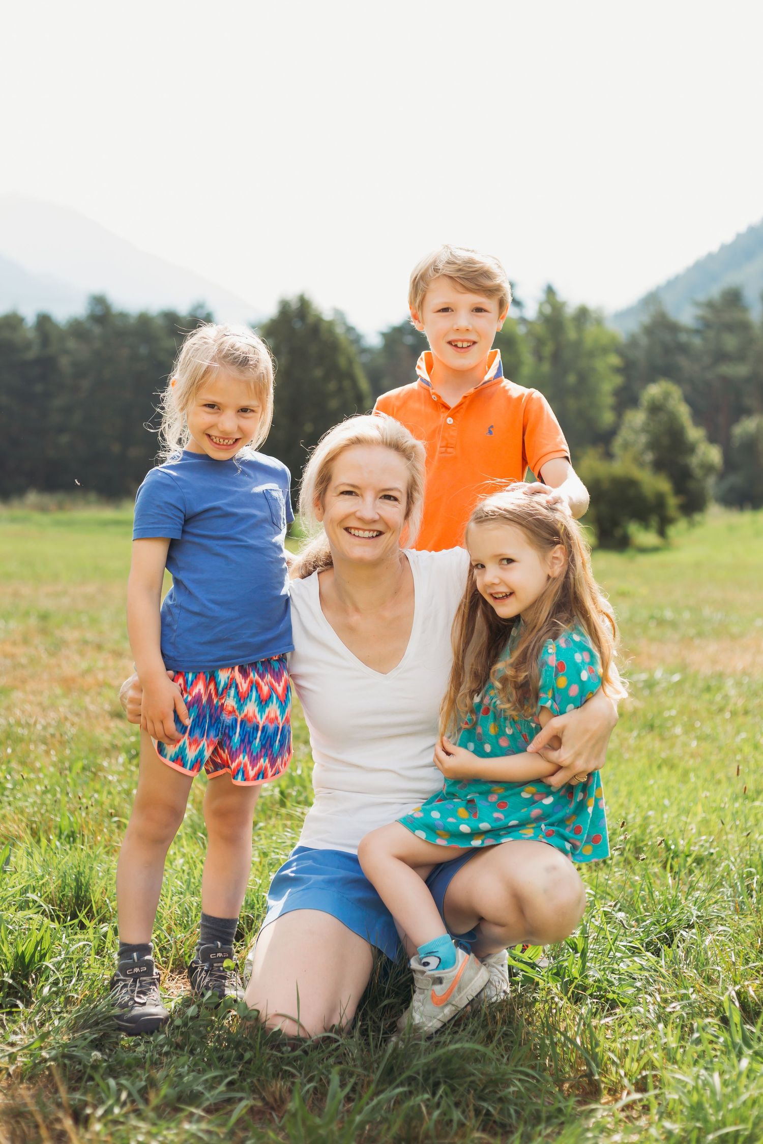 Mother with her three children in field during summer