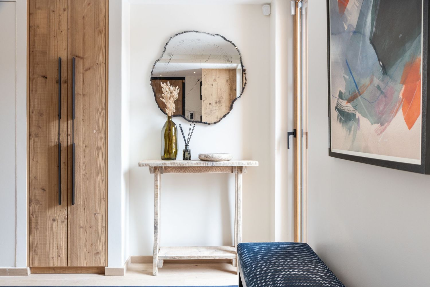 entrance hallway to ski chalet with side table, round mirrors and wall art