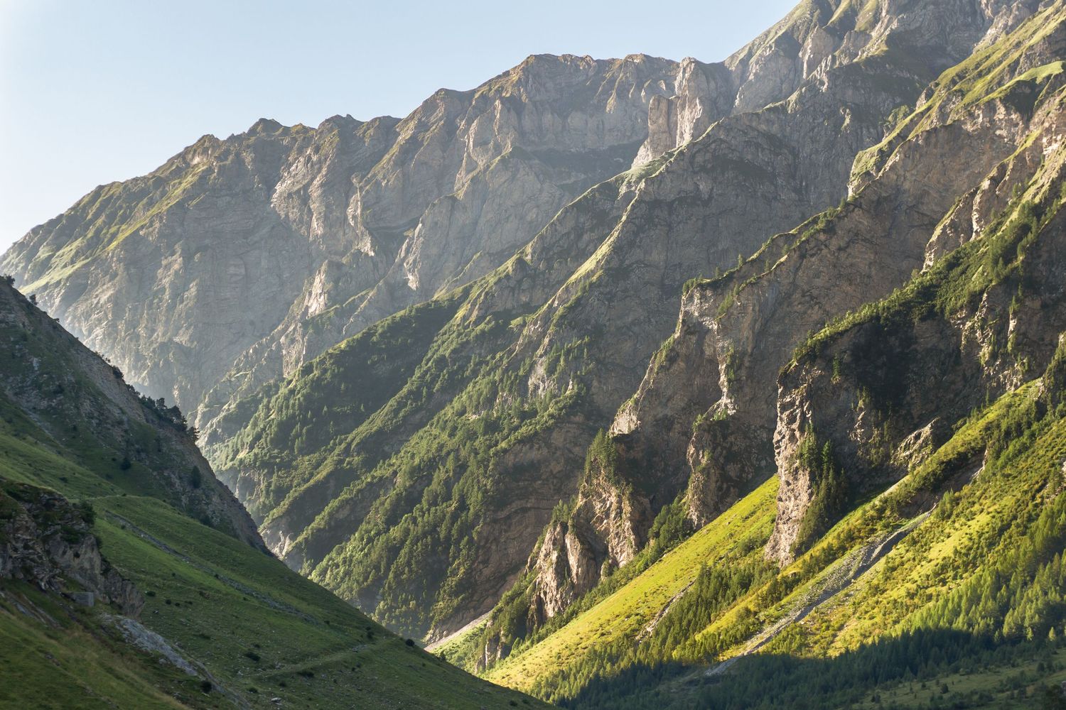 sun hitting a large green mountain