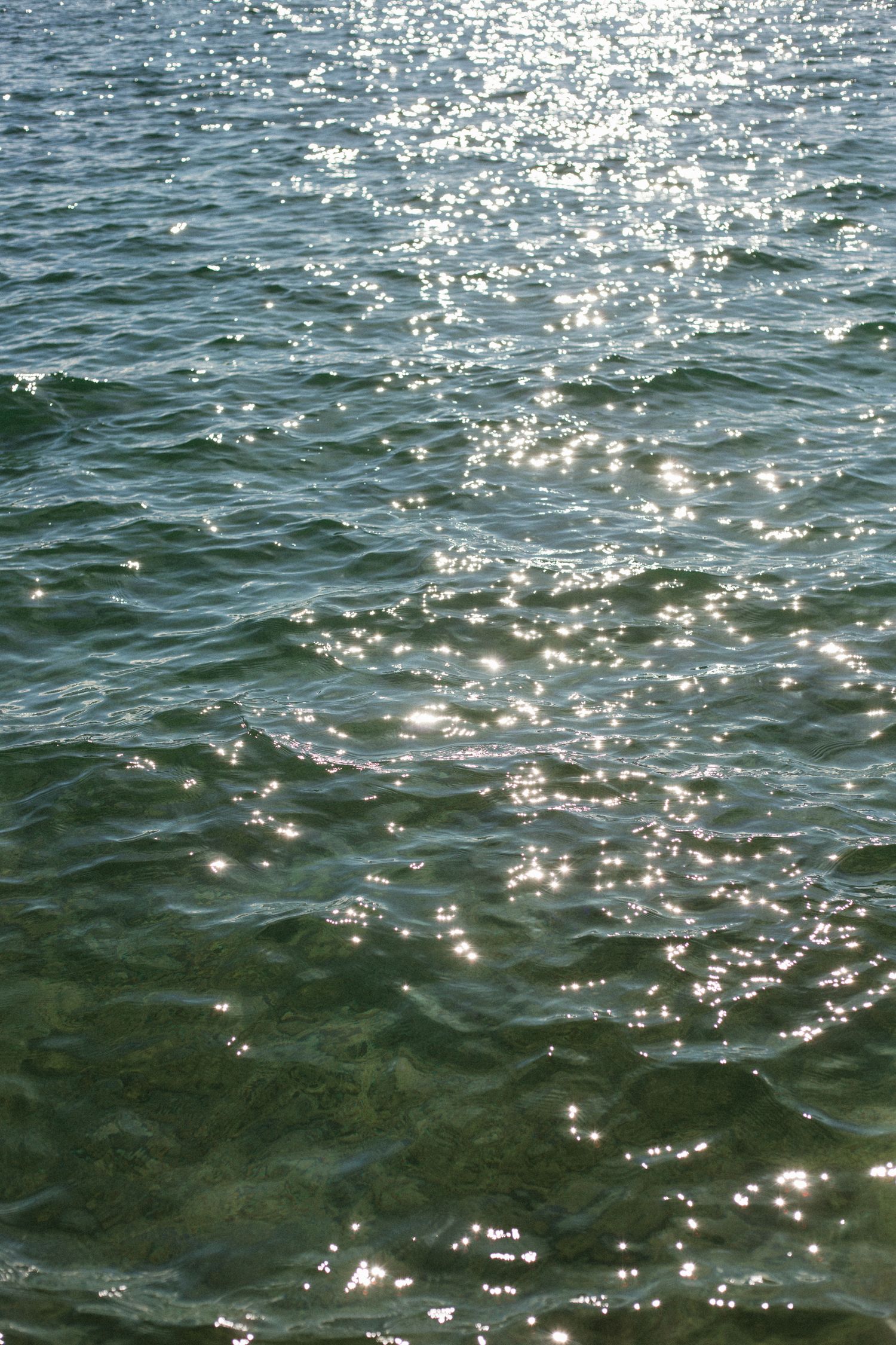 sun sparkles reflecting off a blue lake surface
