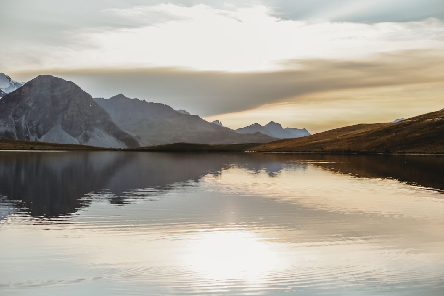 sun set coloured sky reflecting in a high mountain lake