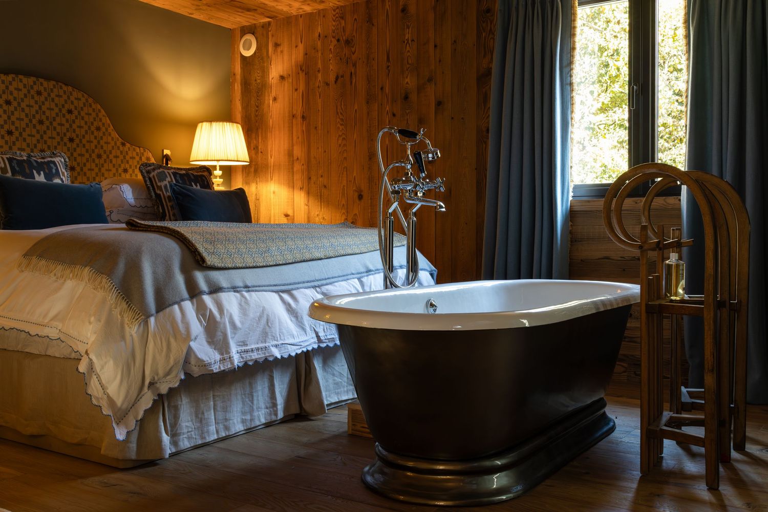 roll top bath at foot of large bed in ski chalet in French alps