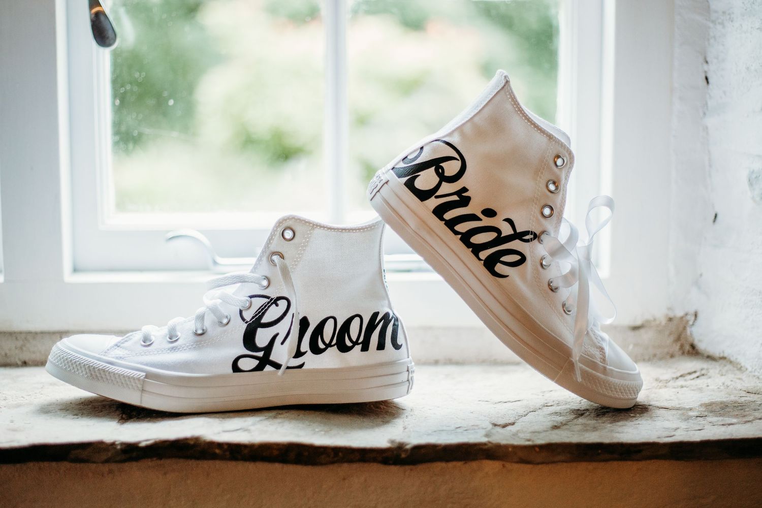 white converse trainers with the word bride and groom on sitting in window