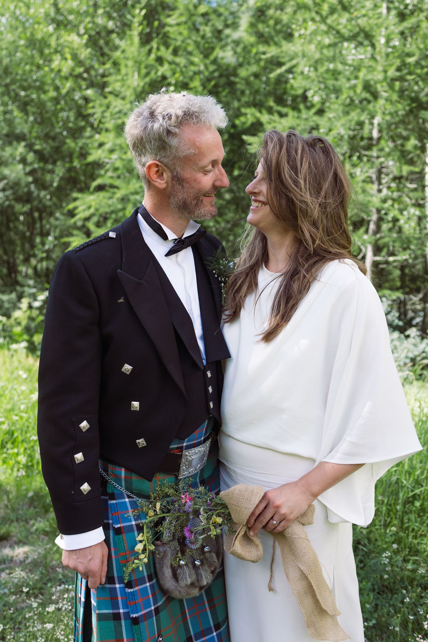 bride and groom stand closely looking at each other