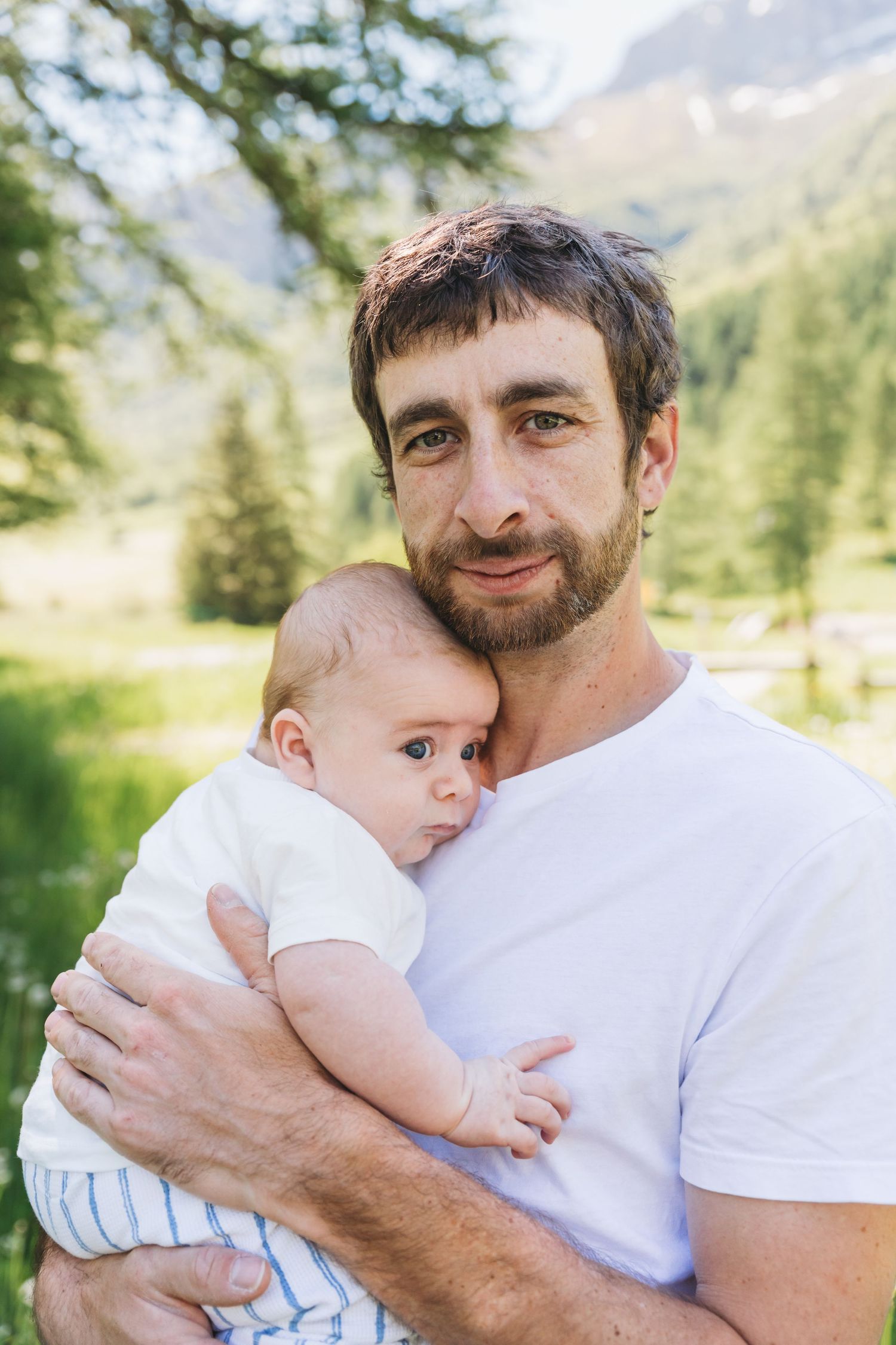 father holds infant son in French alps