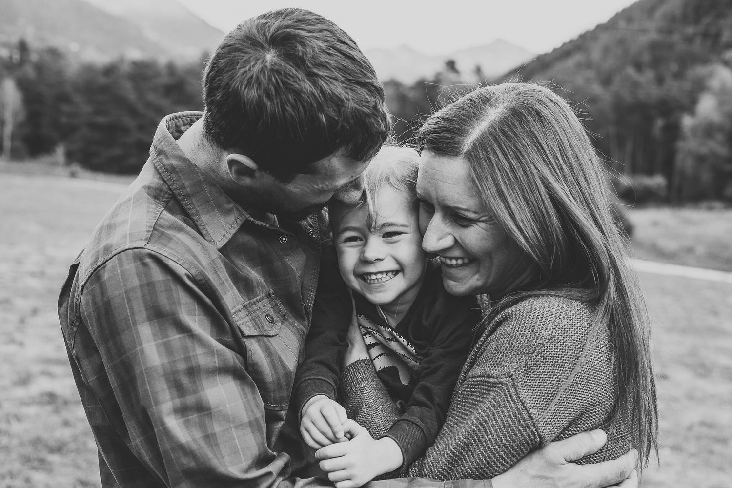 couple snuggle their 4 year old daughter between them