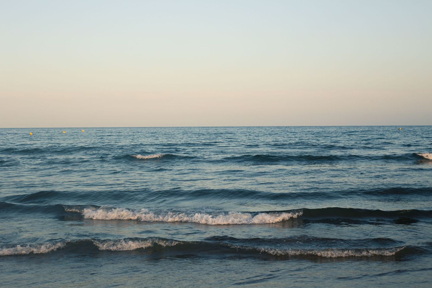 blue waves rolling into the beach at sunset