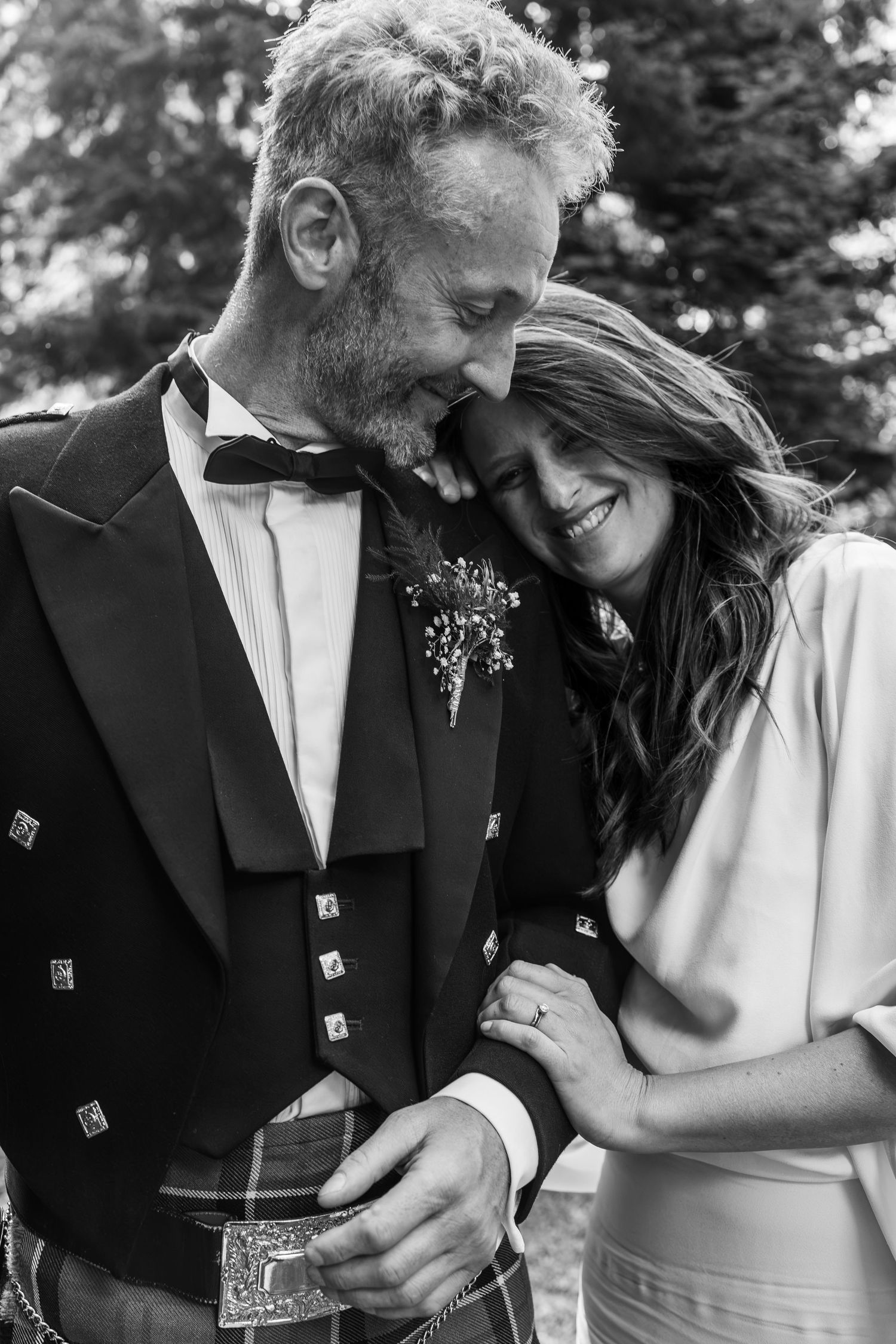 bride rests head on grooms shoulder after wedding
