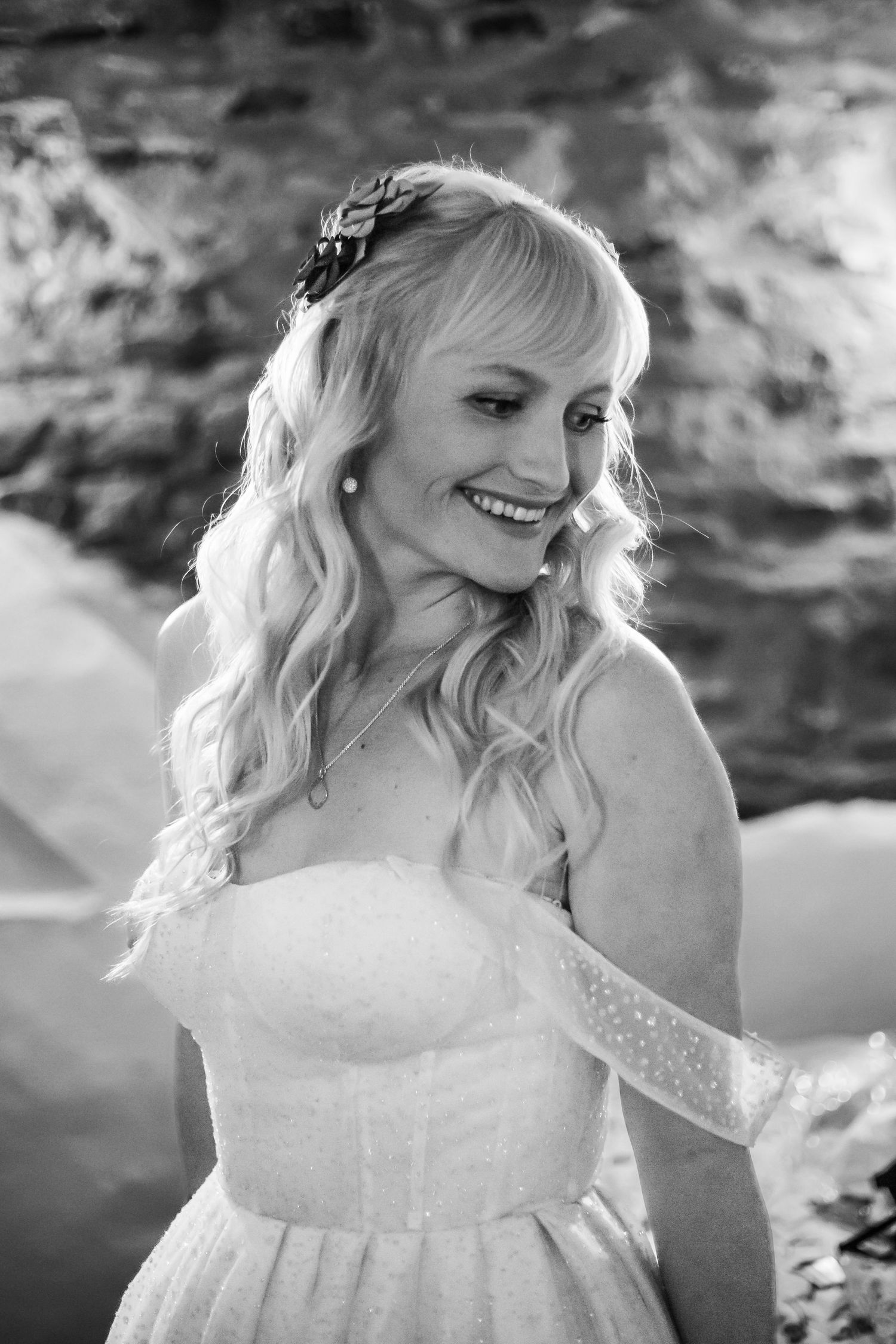 bride in wedding gown looking down at shoulder
