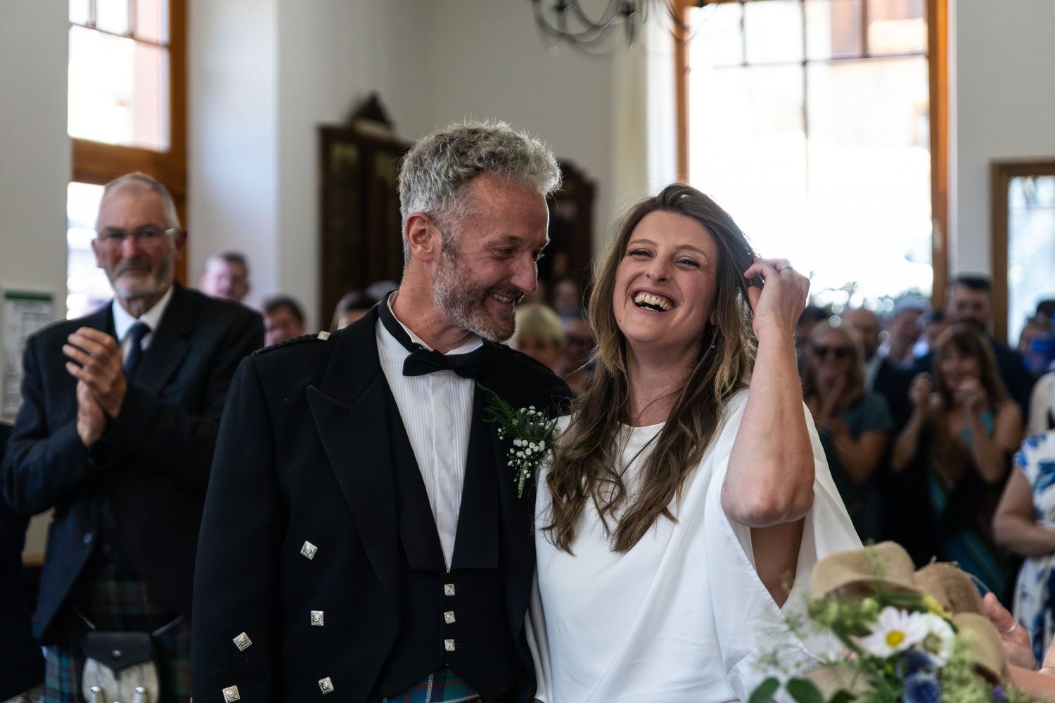 bride laughs next to groom during wedding ceremony