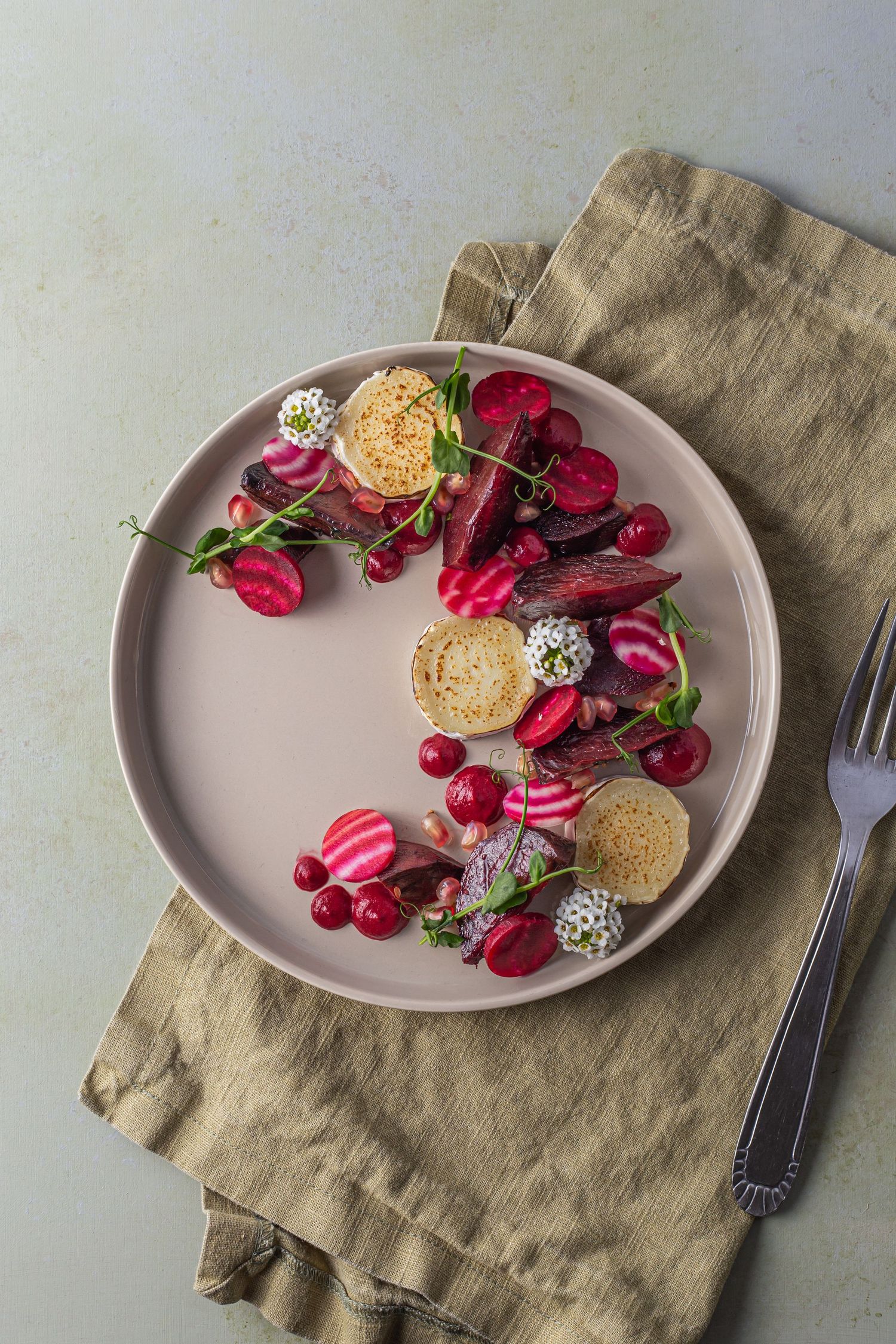 vibrant beetroot salad on a beige plate with sage green napkin