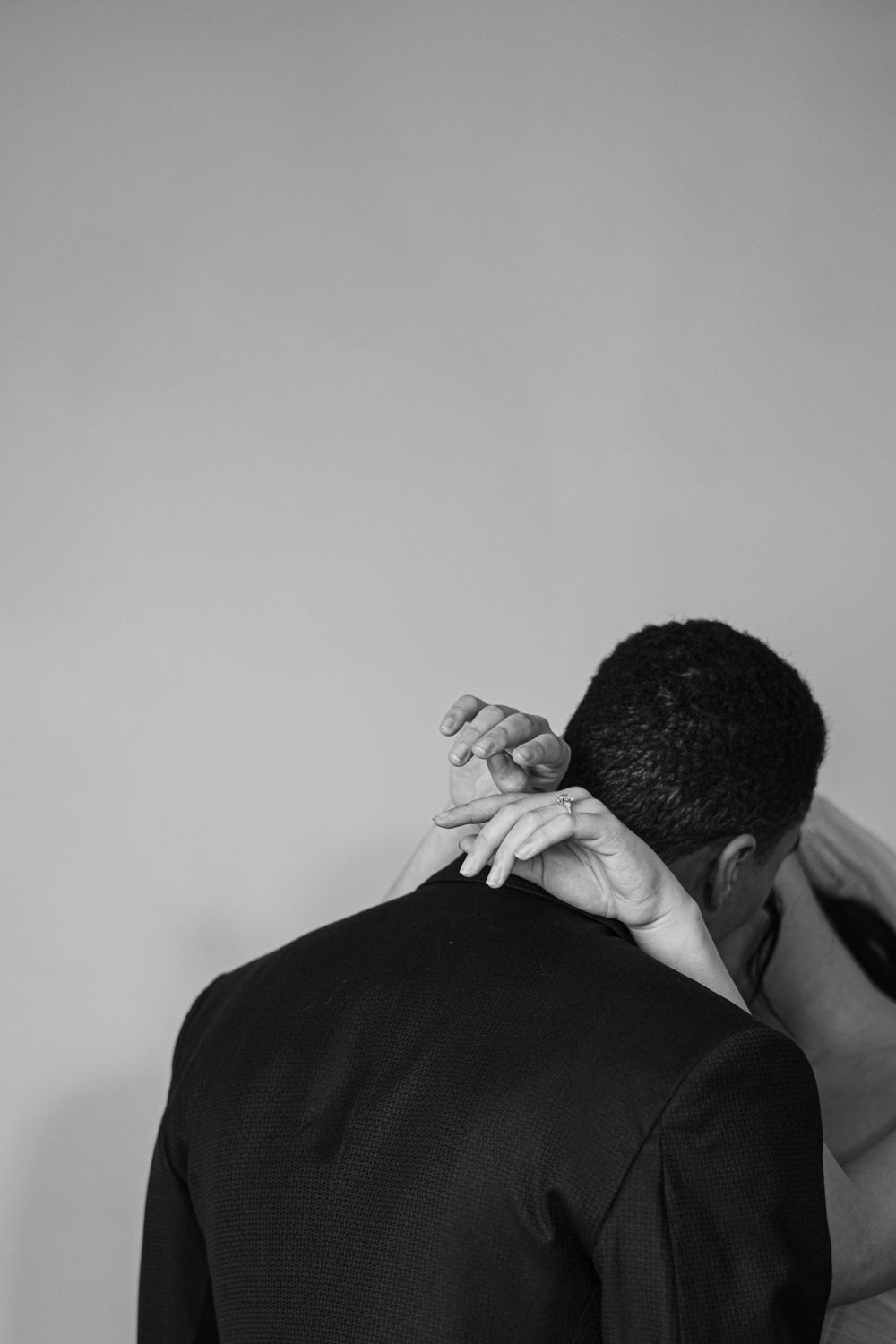 Close-up of a romantic moment between bride and groom, with the bride’s hand resting on the groom’s shoulder. By a Toron