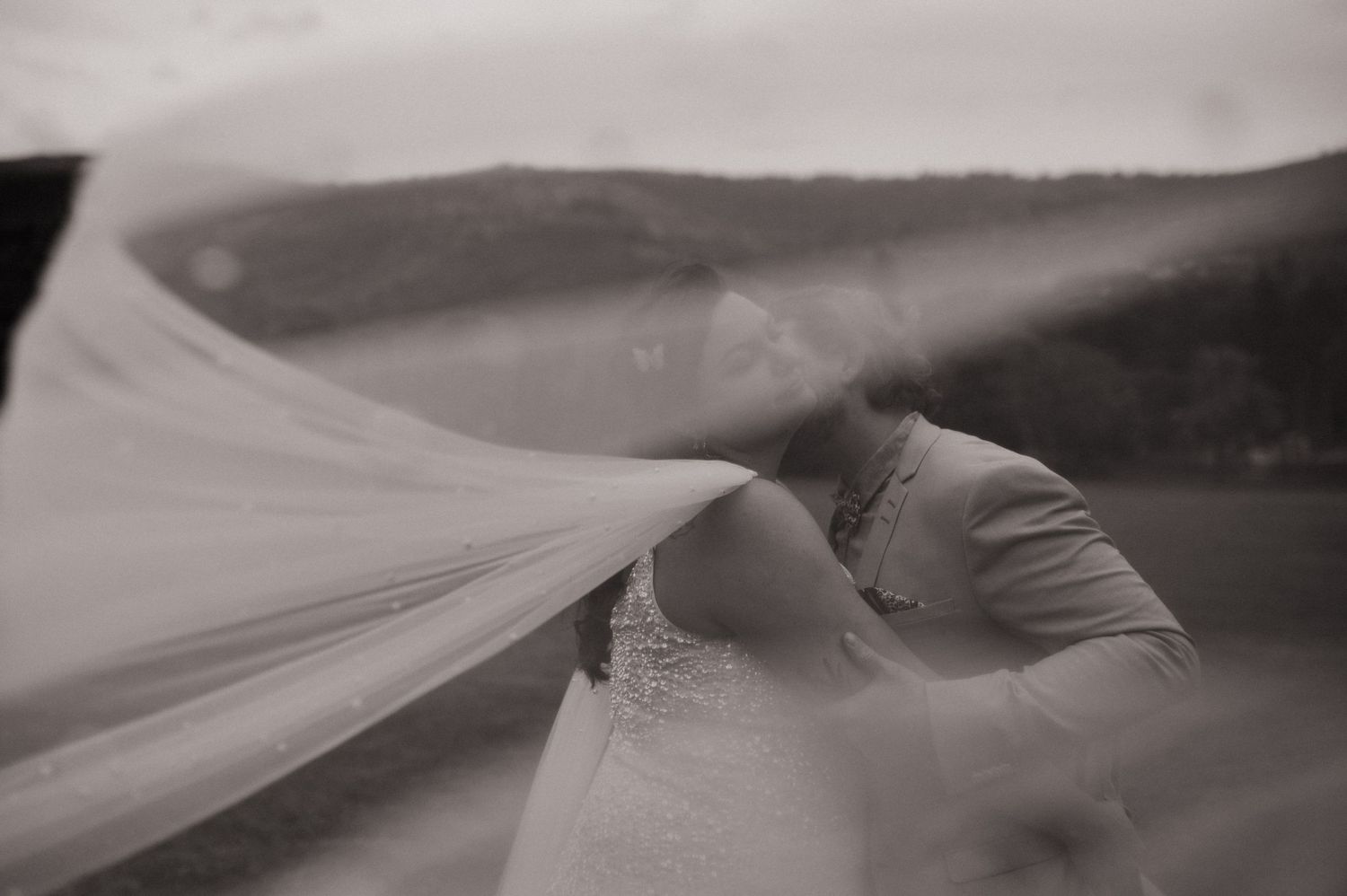 A travers le voile de la mariée on voit les mariés qui s'embrassent .