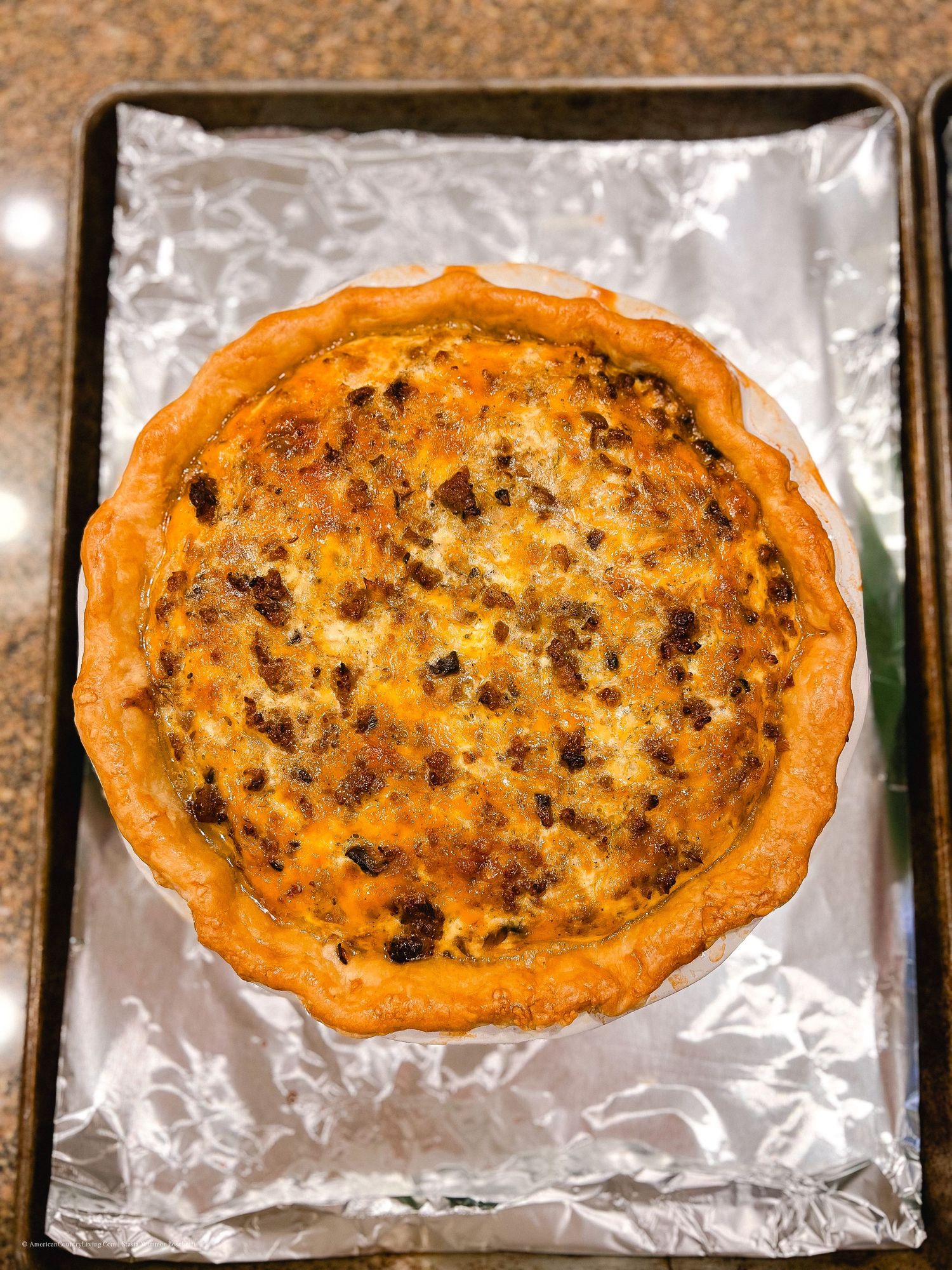 Freshly baked oval-shaped meat pies with crispy golden crusts on foil.