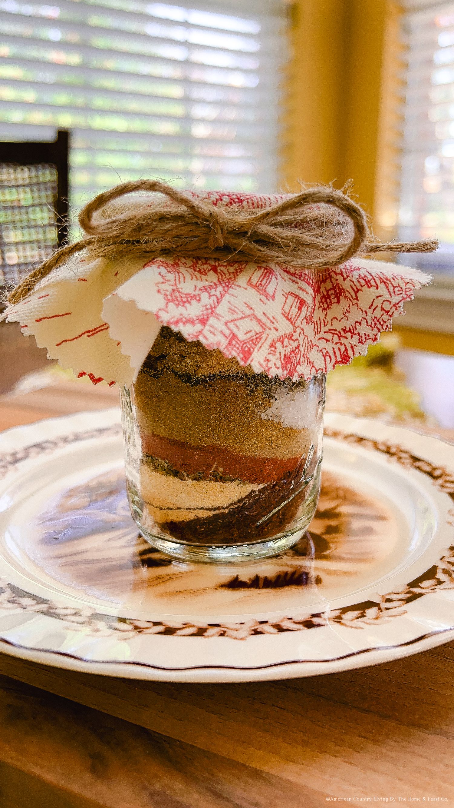 Mason jar filled with chocolate drink mix layers displayed on a decorative plate.