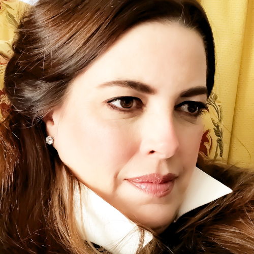 Portrait featuring dark hair and gentle expression against warm-toned background.