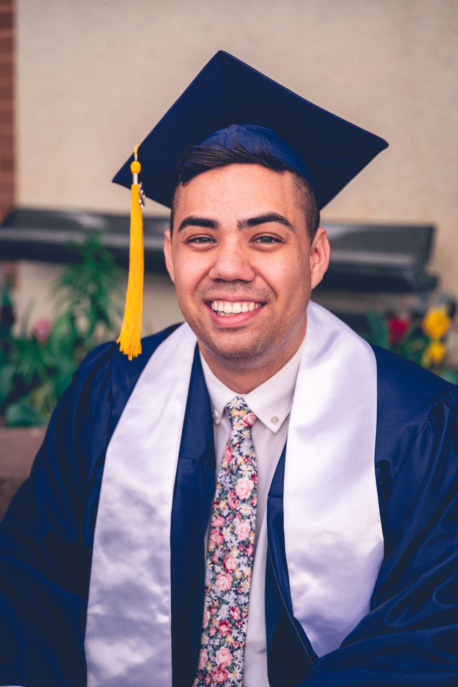 Graduating student smiling in cap and gown for their personalized graduation photography
