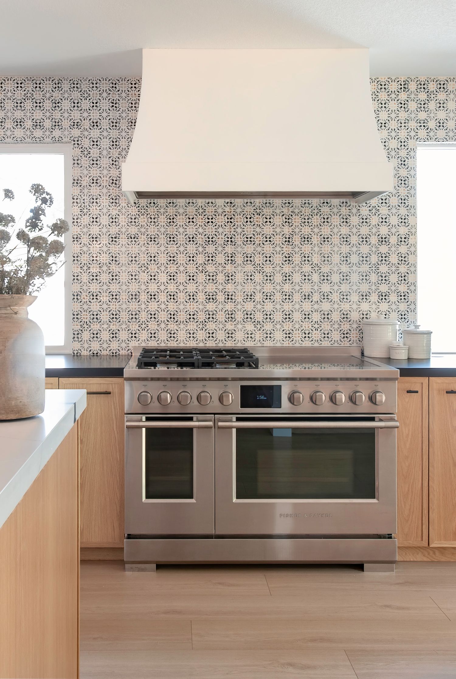 Professional stainless steel range with dual ovens in a contemporary kitchen setting.