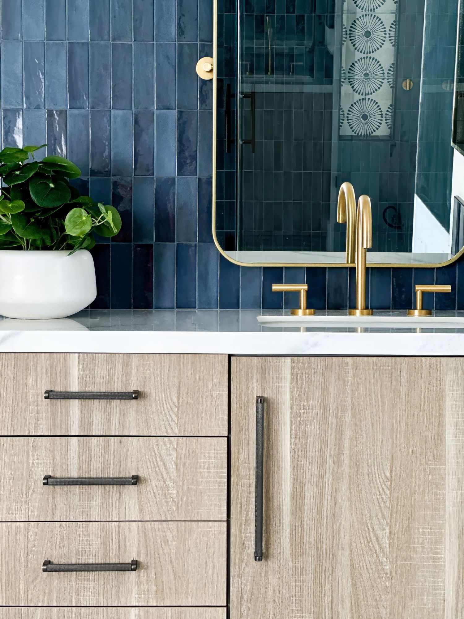 Contemporary bathroom vanity with light wood cabinets and navy blue tile backsplash photographed by interior designer photographer in SoCal.