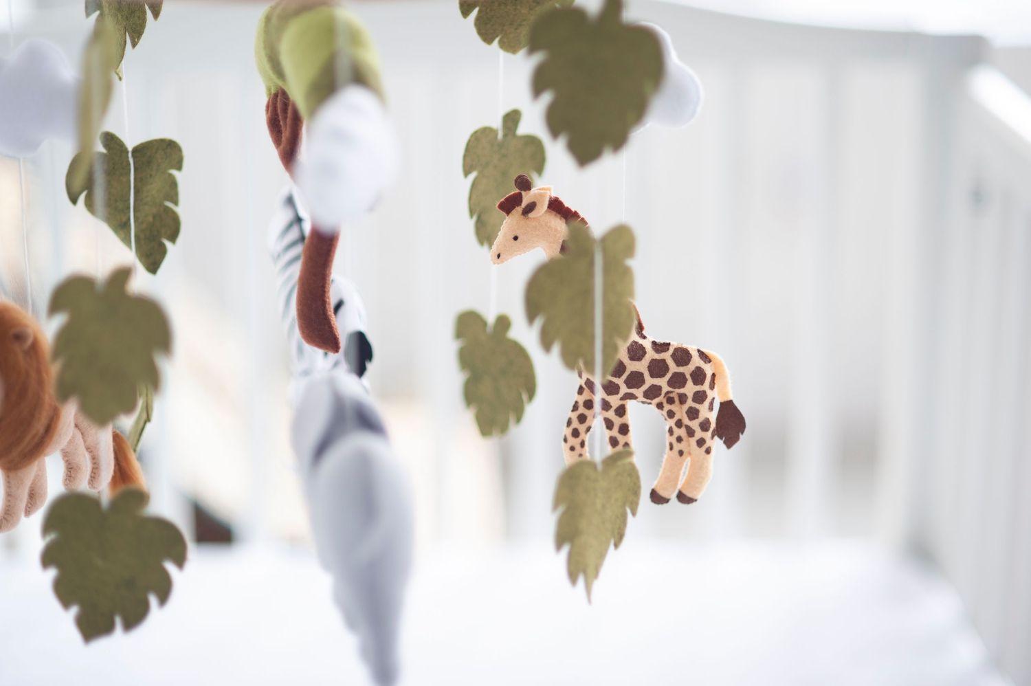 Decorative animal-themed mobile hanging with safari creatures against a white background.