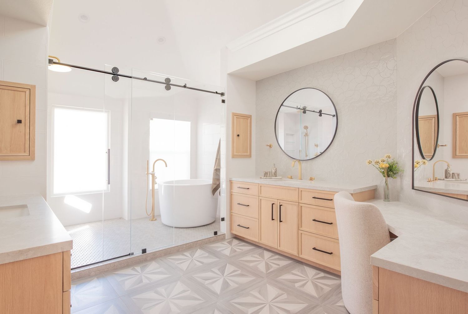 Interior photograph of bright, open bathroom vanity area with round mirrors, wood cabinets, and modern fixtures.