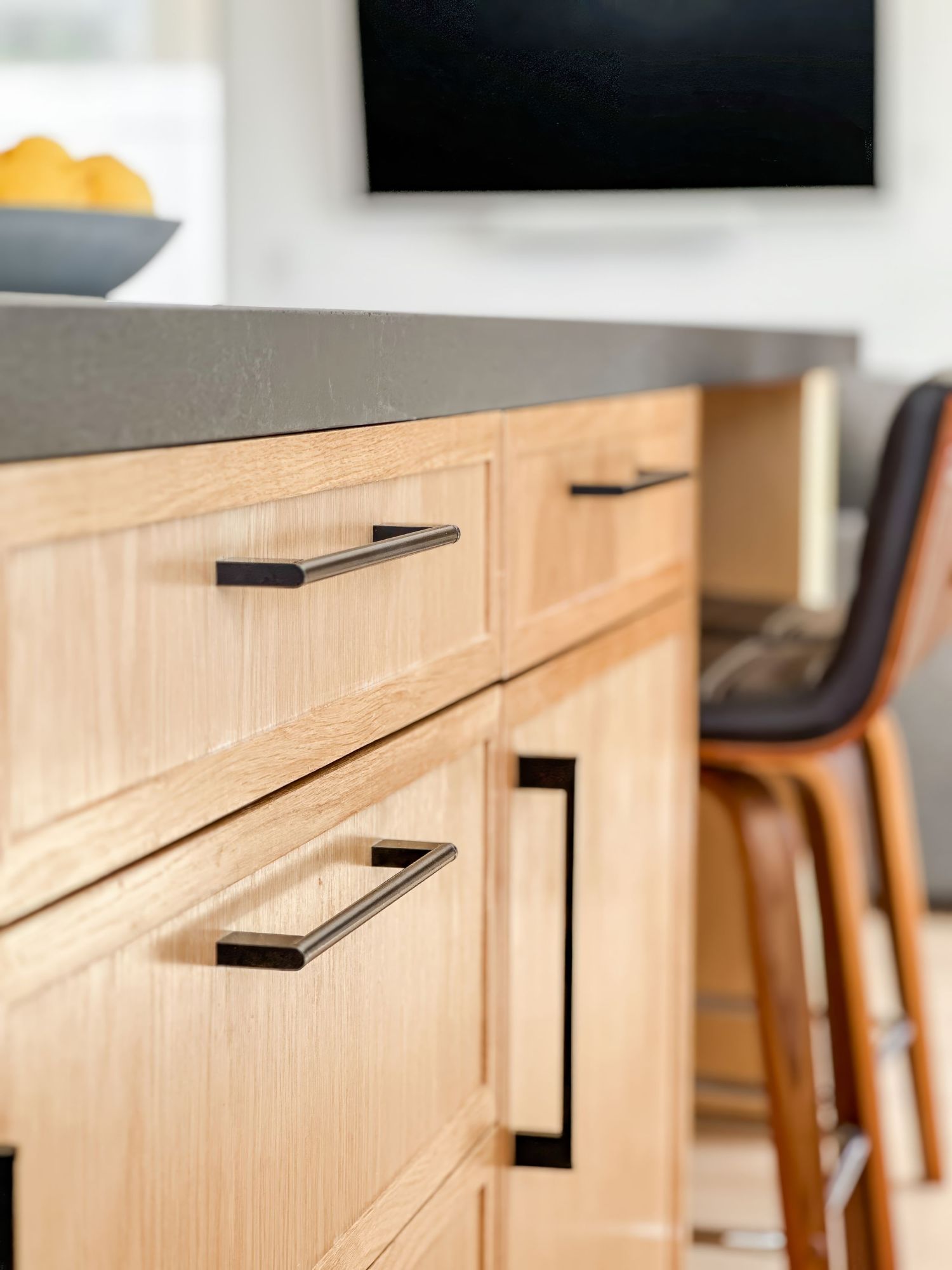 Light wood island cabinets with black handles in contemporary style photographed by interior designer photographer in Southern California.