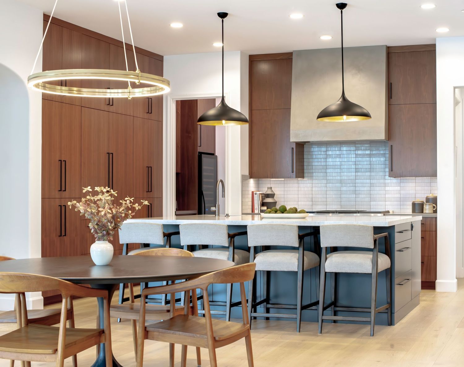 Open concept dining and kitchen space with modern furniture and pendant lighting photographed by Daniela Volpi.