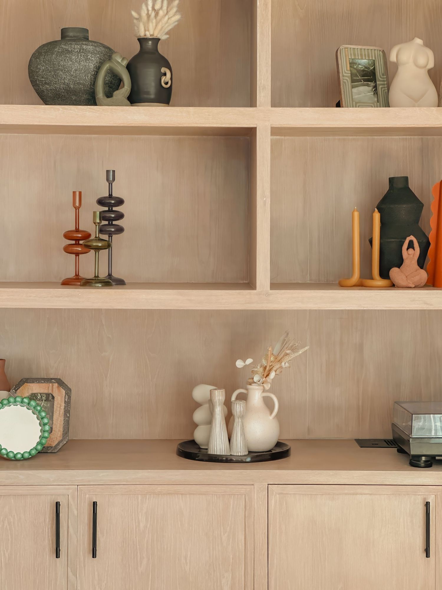 Built-in shelving unit displaying decorative vases, ceramics and ornamental objects.