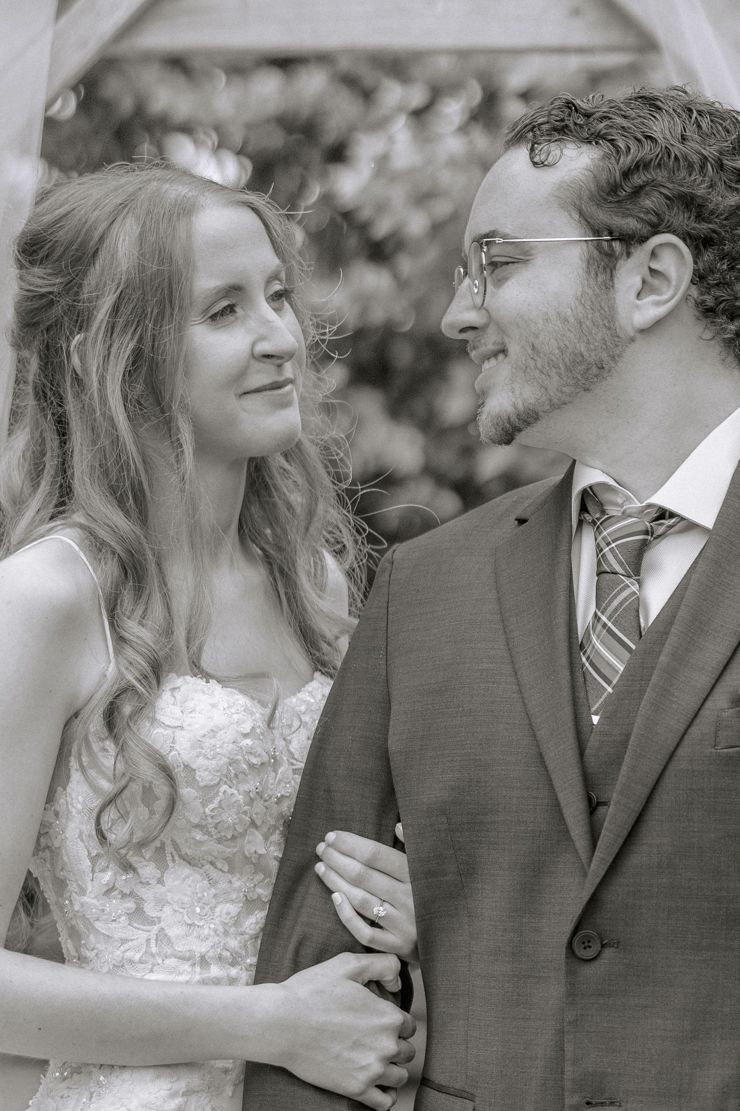 A romantic black and white wedding photo sequence showing a couple sharing tender moments together outdoors.
