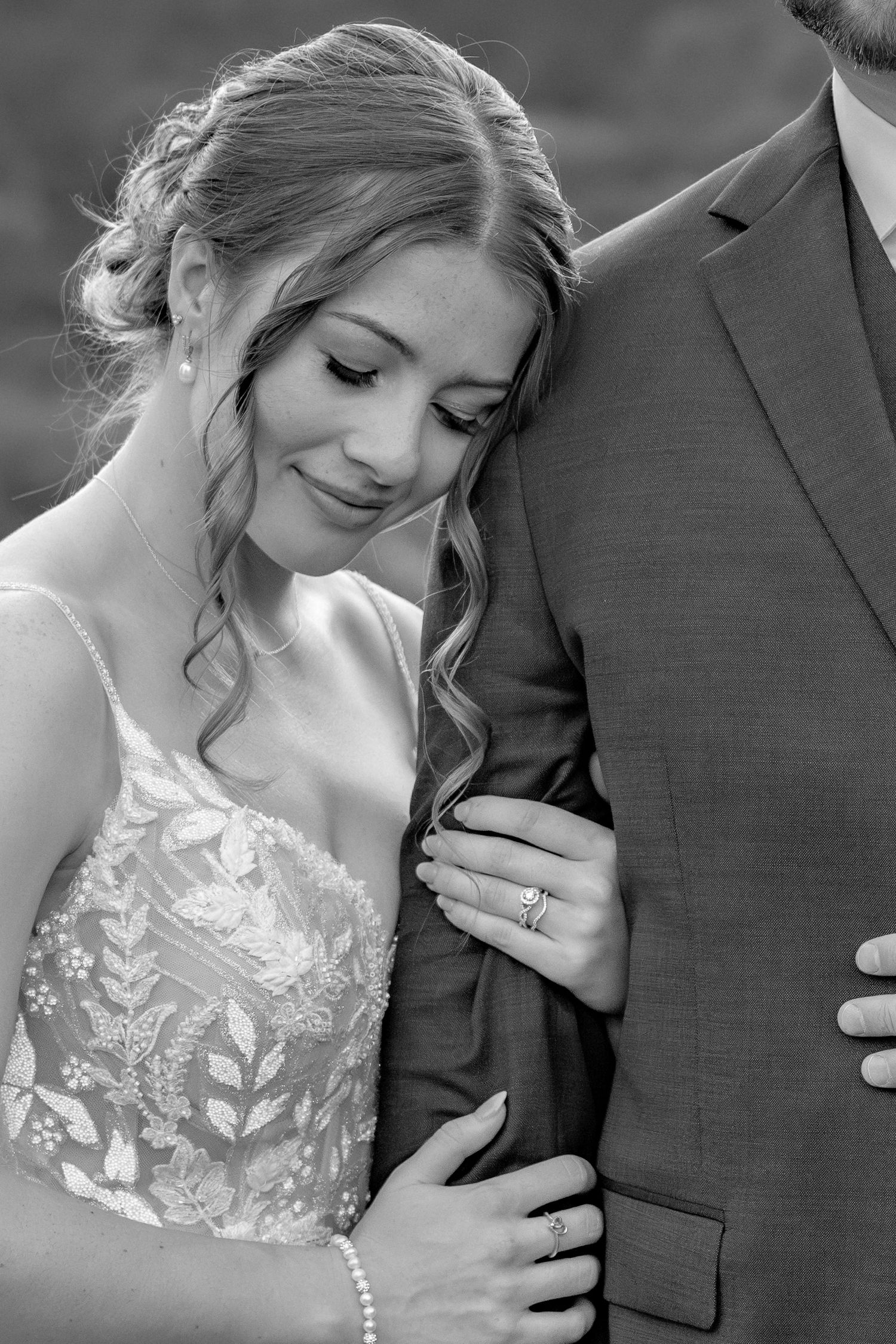 Black and white intimate portrait of newlyweds in formal wedding attire.