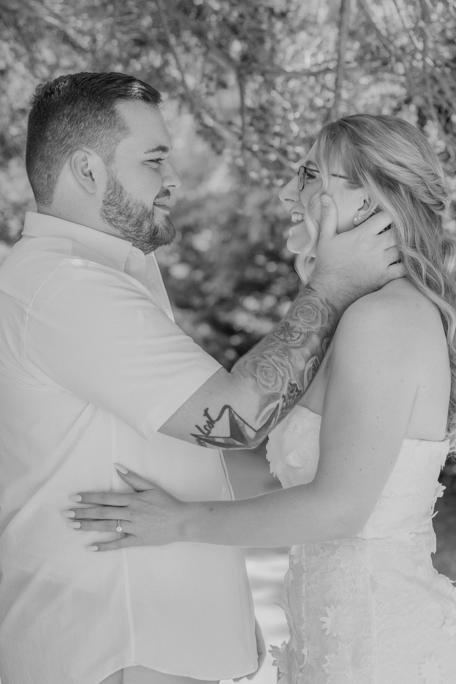 A couple shares a joyful moment together during their wedding photoshoot in black and white.