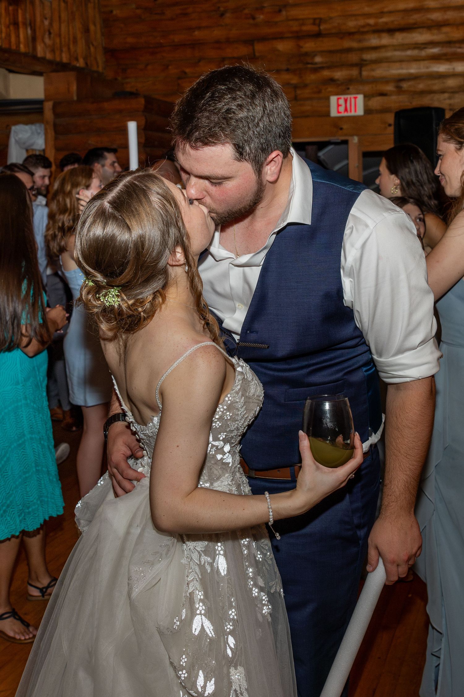 Intimate dance moment during wedding reception in rustic wooden venue.