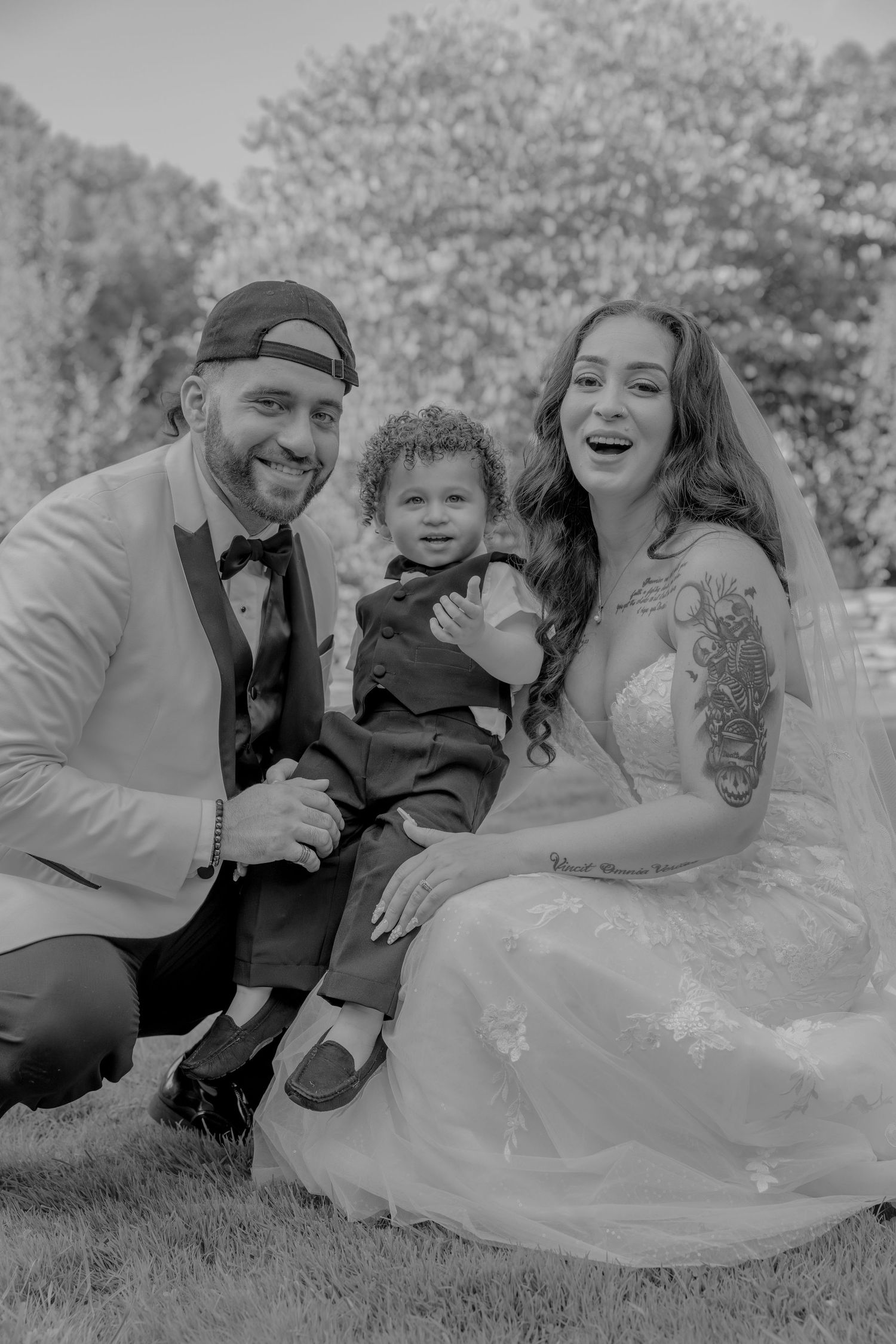 Wedding portrait in black and white featuring happy family moment outdoors.