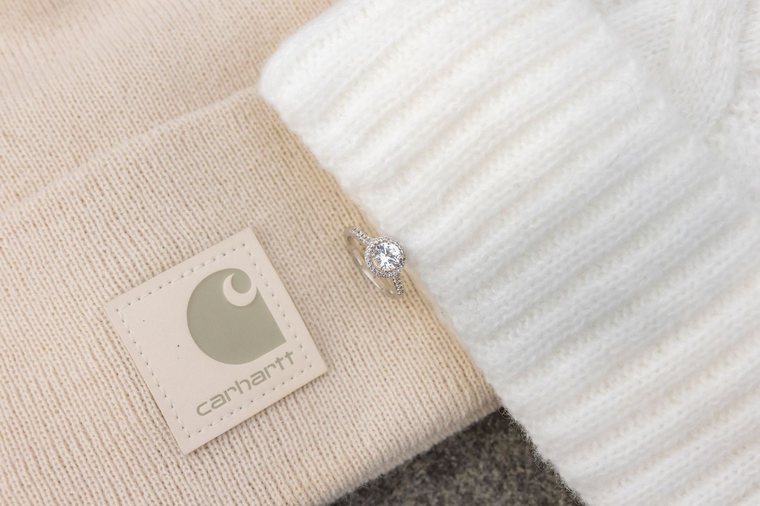Detail shot of a Carhartt beanie label next to a white knit fabric with diamond ring.