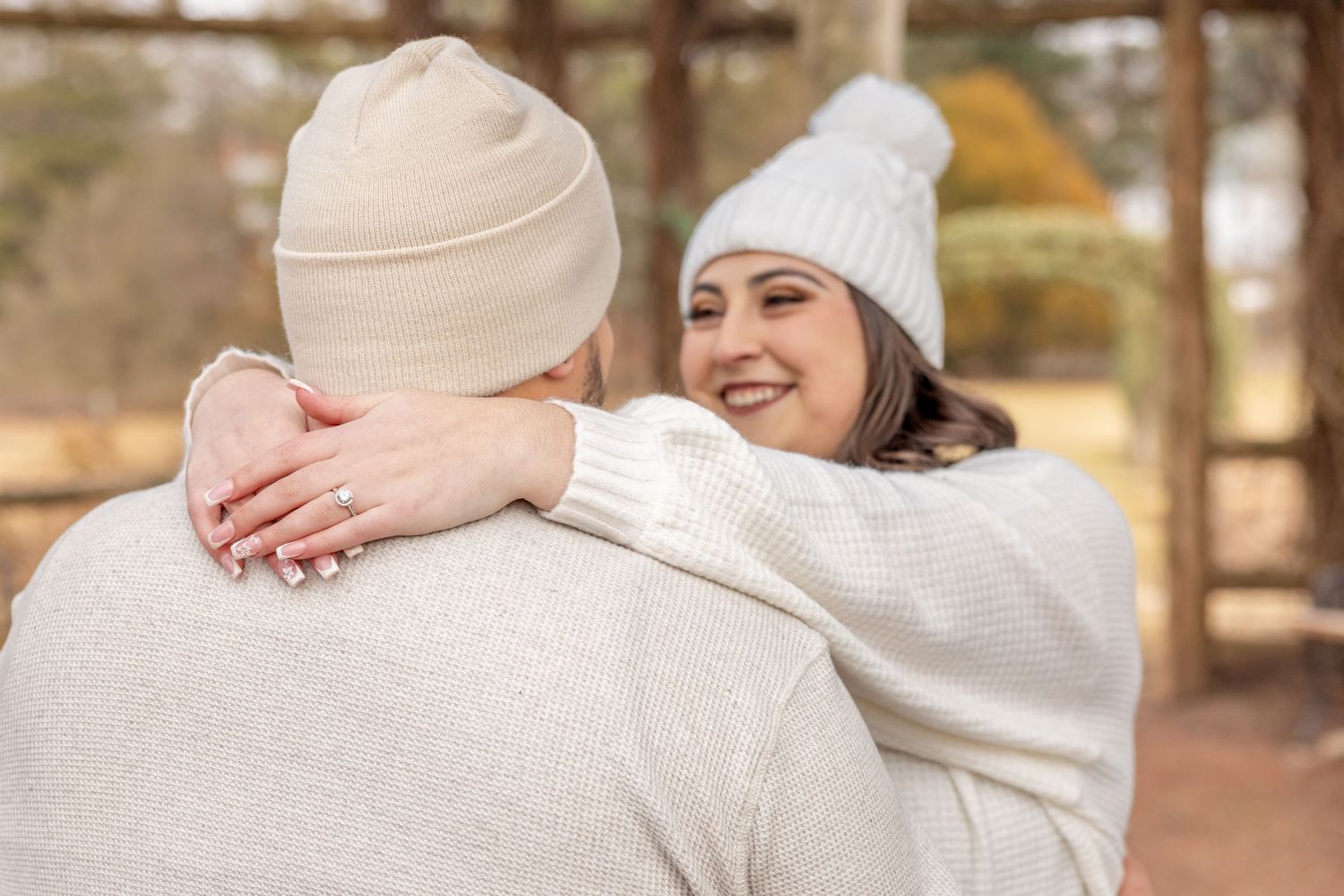 Candid shot of a joyful couple embracing in matching winter white outfits.