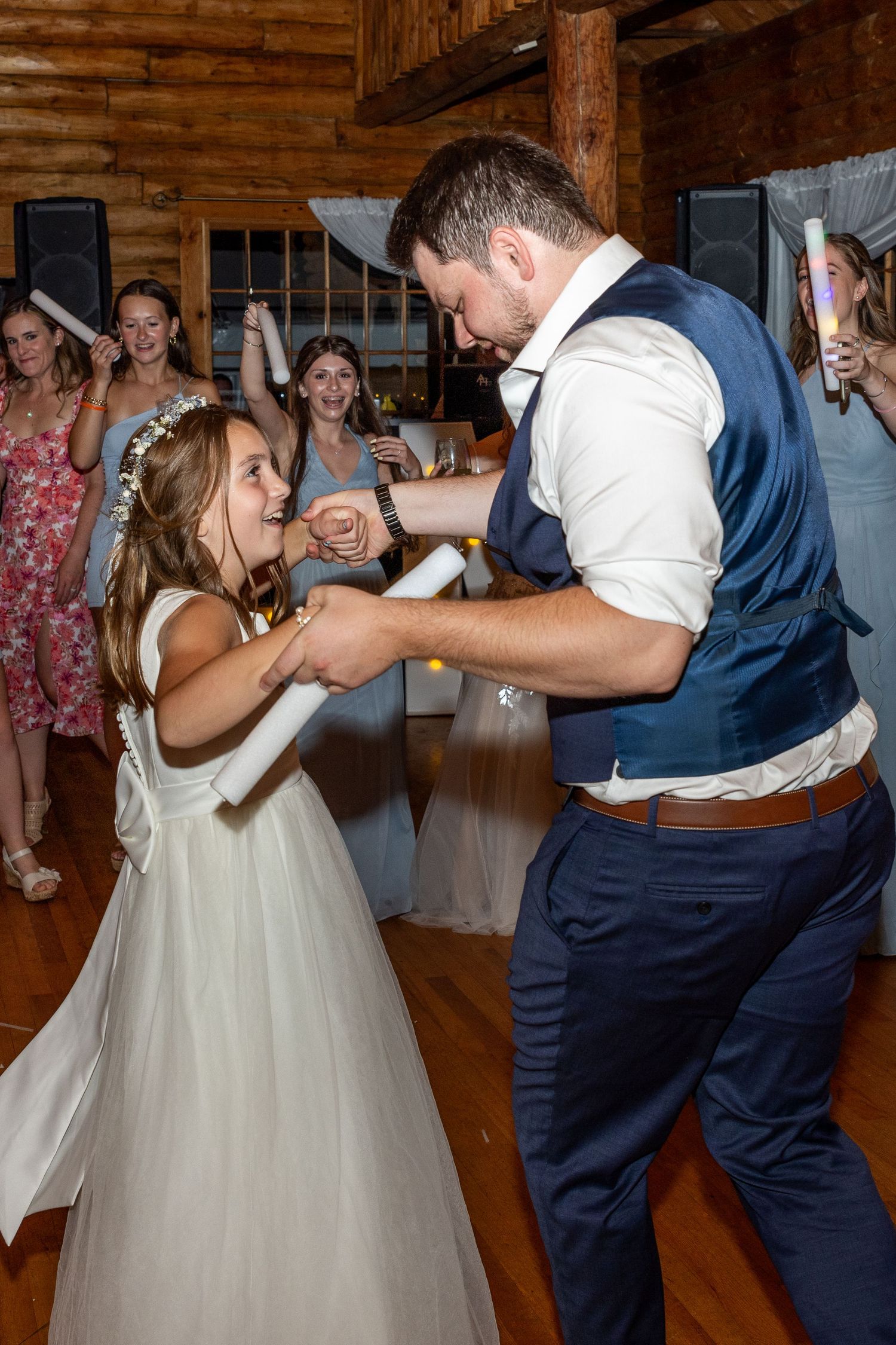 Joyful dancing moment captured on a wooden dance floor during wedding reception.