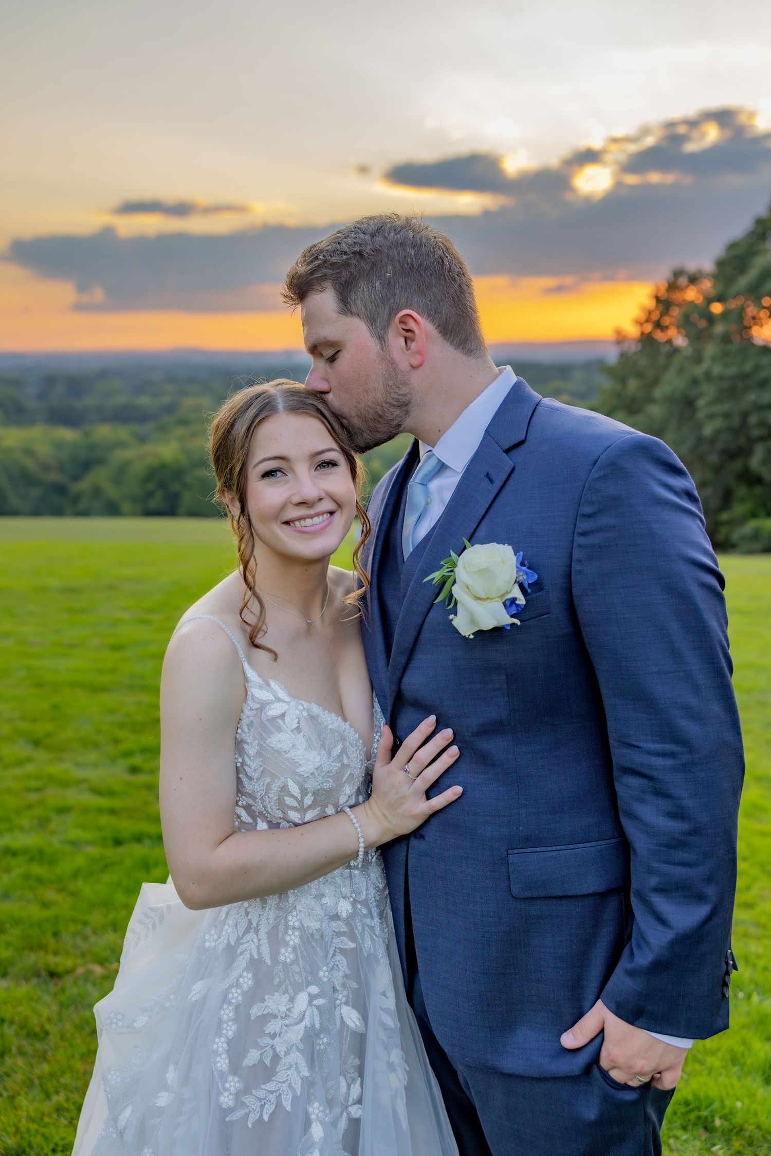 Romantic sunset wedding portrait on a hilltop with dramatic golden sky.