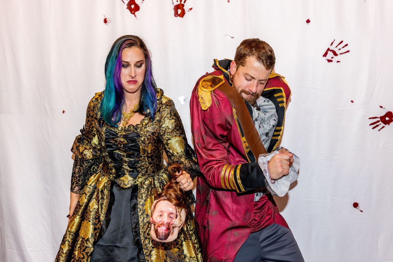Theatrical scene with performers in elaborate period costumes striking dramatic poses.