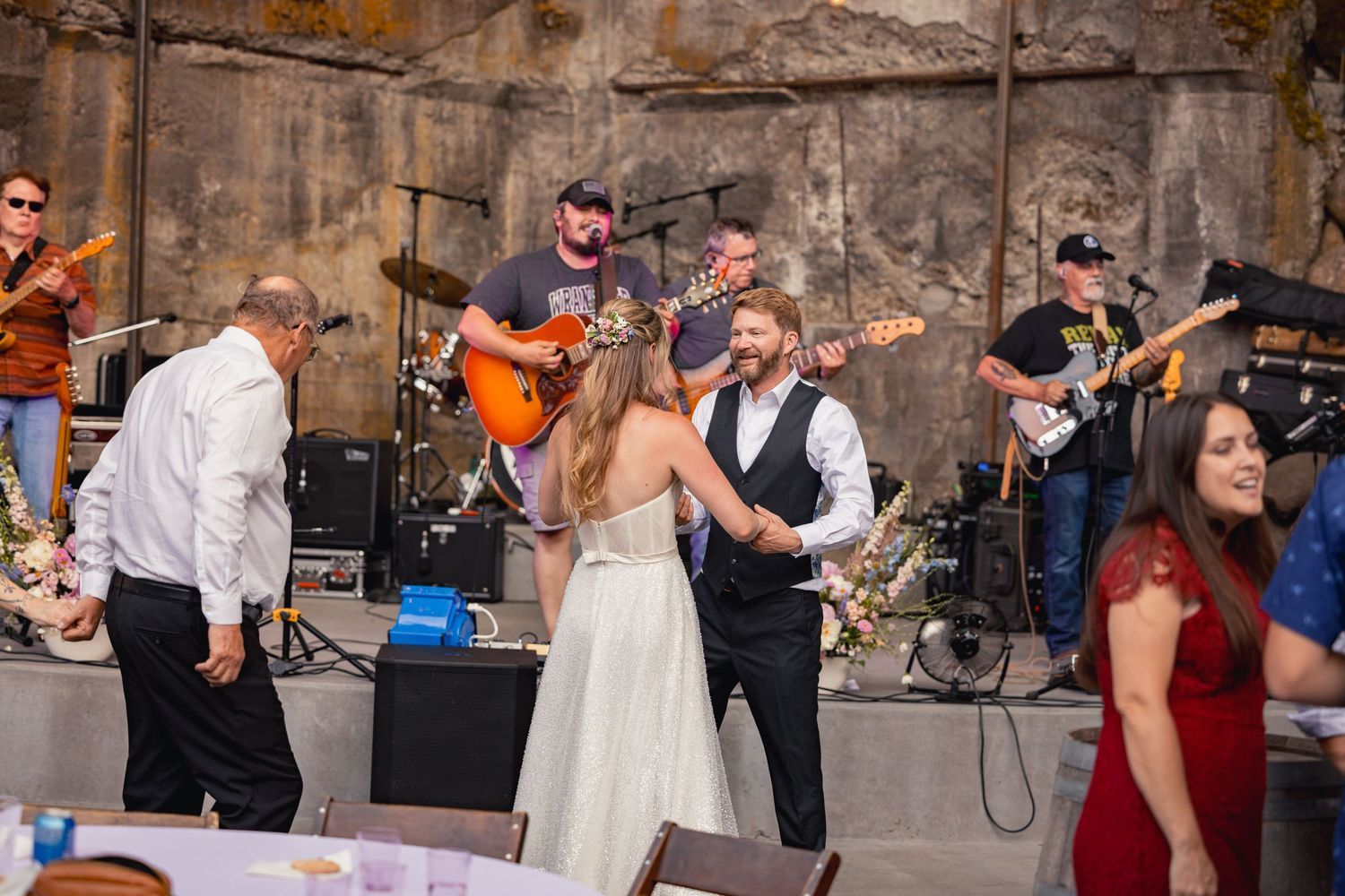 Wedding celebration with live band playing music while couple dances at outdoor reception venue.
