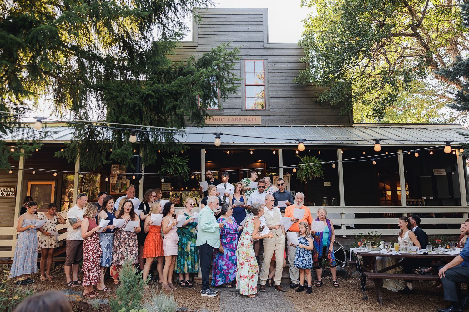 Wedding guests gather on a rustic outdoor patio during a reception celebration.