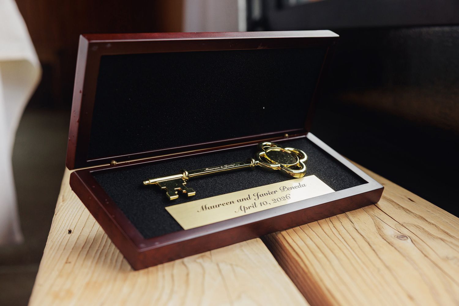 Gold ceremonial key in a wooden display box with engraved nameplate for a wedding gift.
