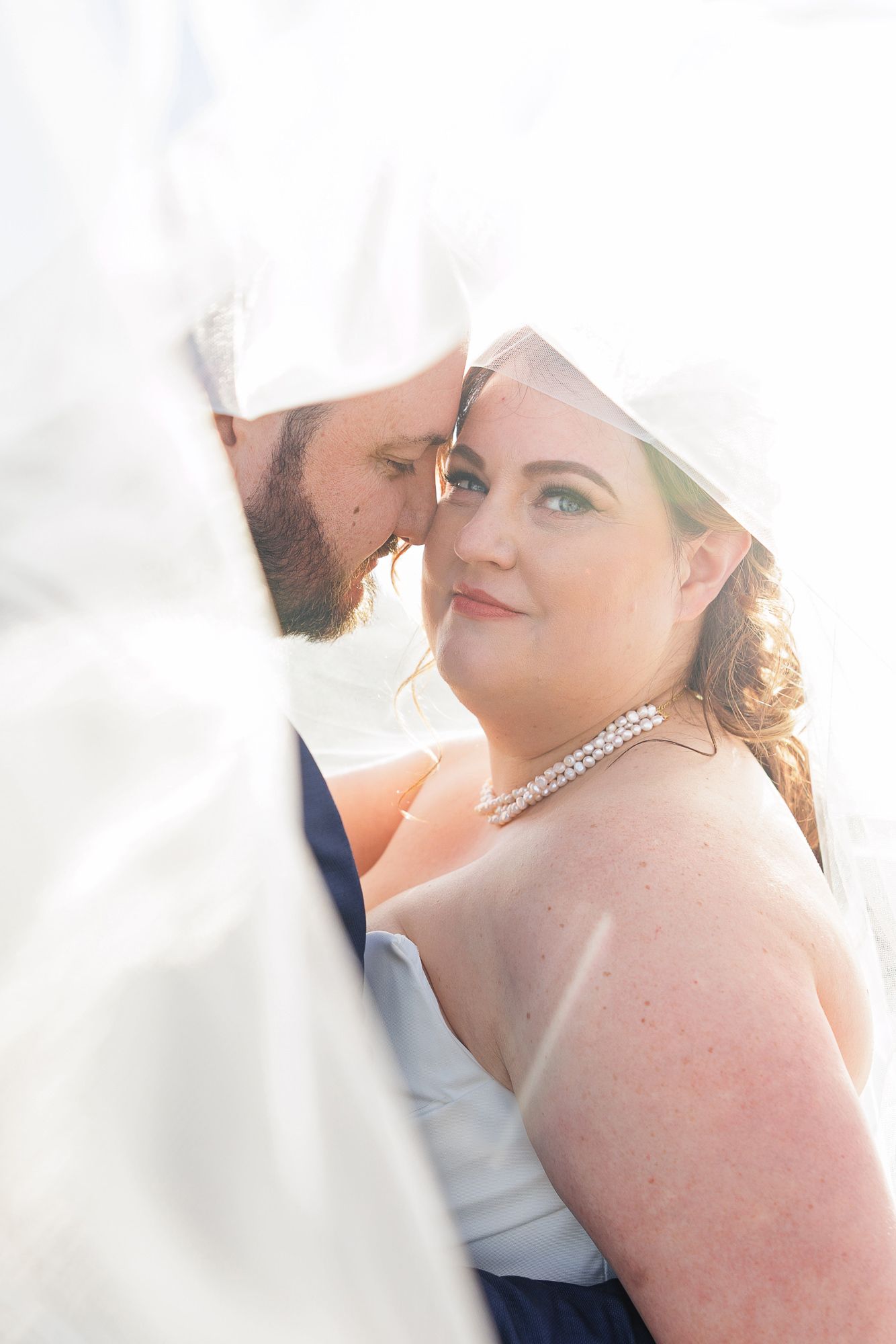 Elegant wedding party poses together in soft sunlight creating a dreamy romantic atmosphere.