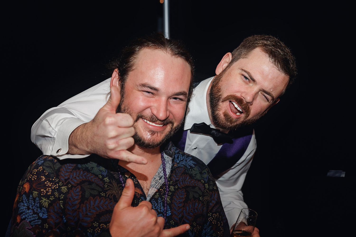 Two people sharing a joyful moment at a dimly lit celebration event.