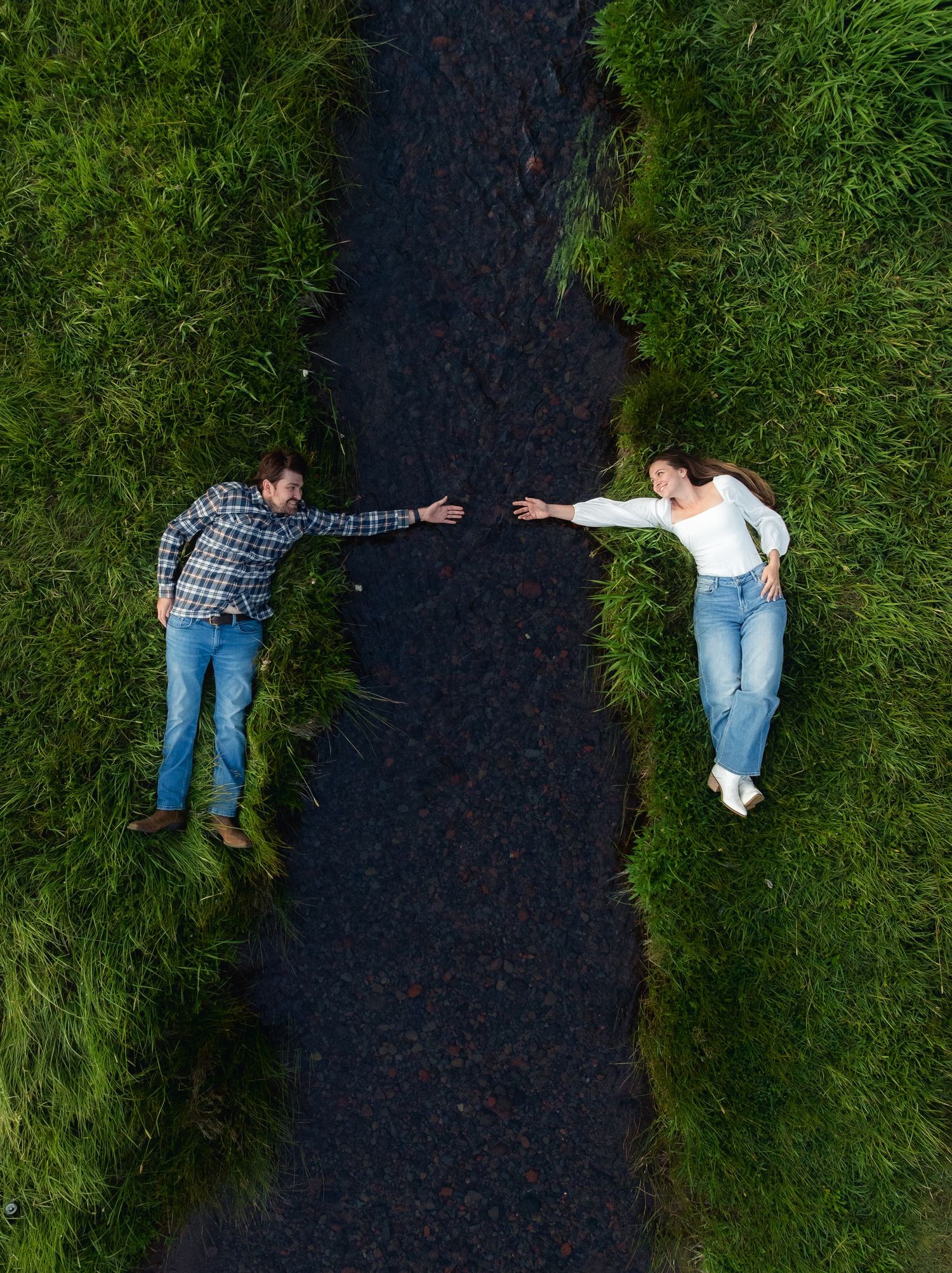 Creative photo sequence showing silhouettes lying side by side between asphalt road and green grass.