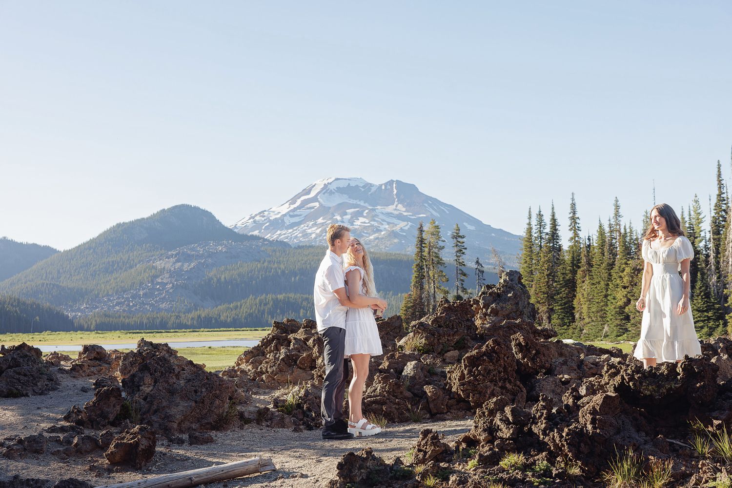 Couple sharing a romantic moment at outdoor mountain elopement ceremony with scenic volcanic landscape backdrop.