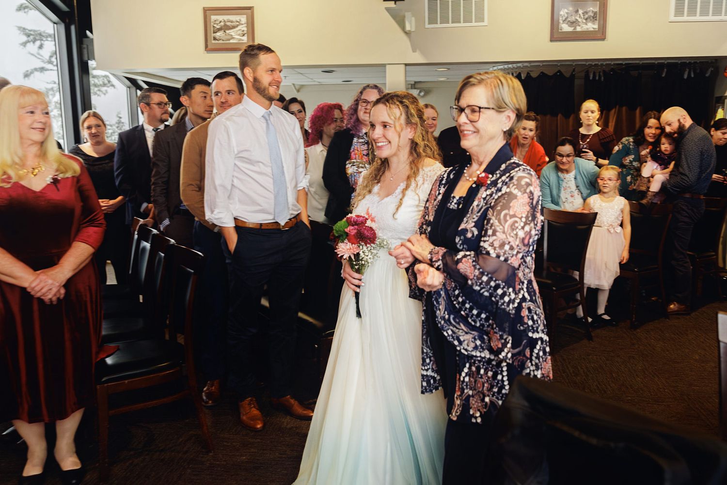 Wedding guests dance and celebrate together on a crowded dance floor at an evening reception.